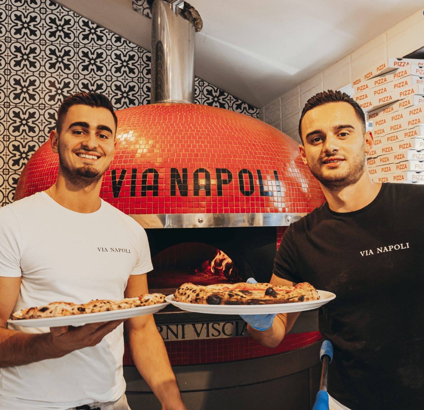 De twee broers, oprichters, voor de pizzaoven van Via Napoli Pizzeria